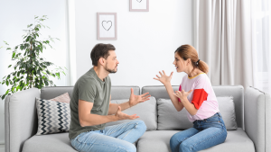 Exasperated wife and confused husband on a couch, illustrating marital tension covered in the article.