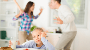 Child looking sad while parents argue in the background, showing how emotional triggers and conflict in marriage affect the family