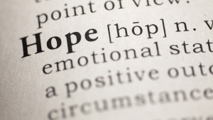 Close-up of a dictionary definition of the word hope, representing realistic hope without denial